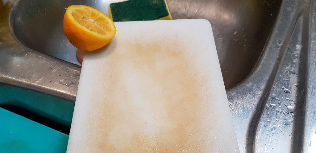 a small cutting board cleaned by a lemon half.