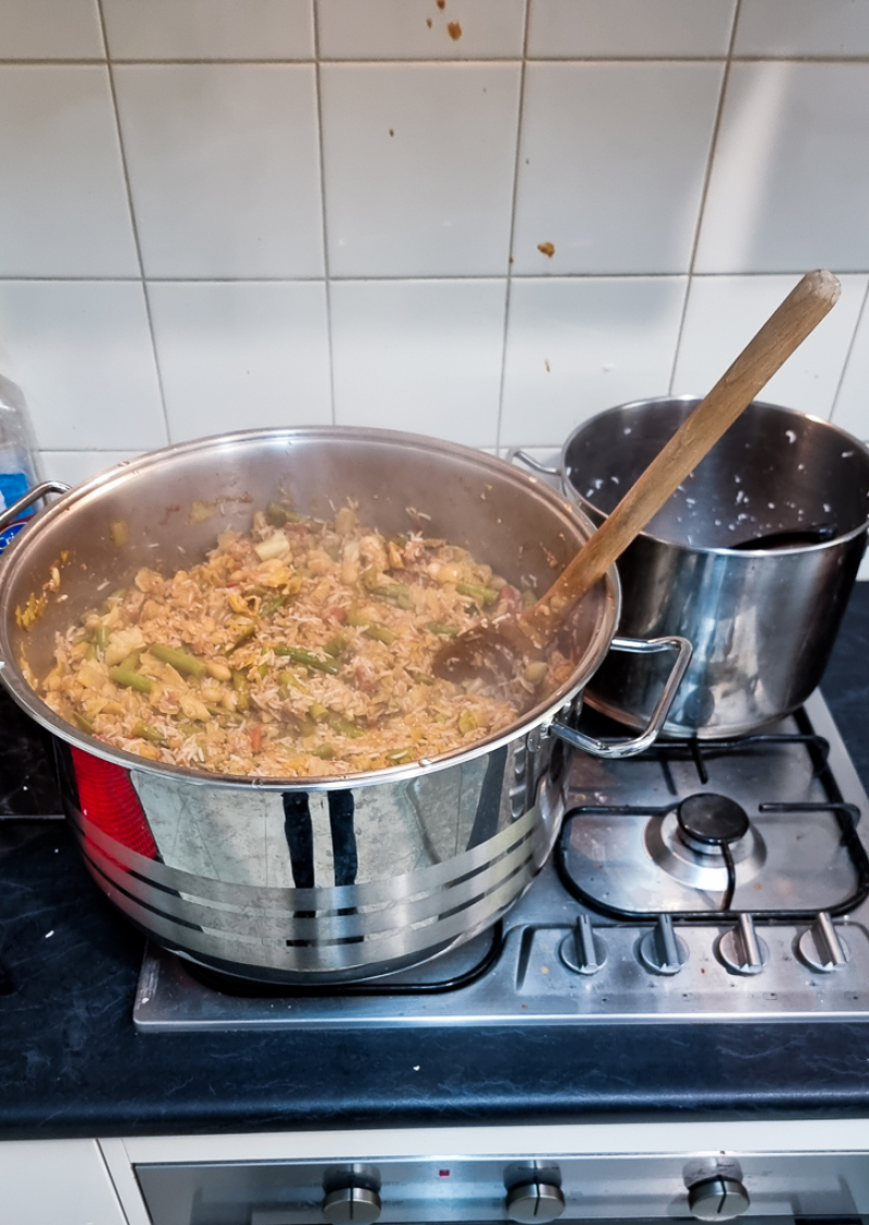 A stove with a pot on it containing enough curry to last two weeks of not cooking.