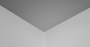 A black and white photo of a ceiling with no cornice.