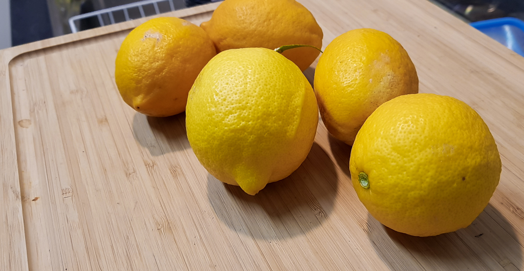 An assortment of lemons on the official Bradism Raised Cutting Board for Tall People