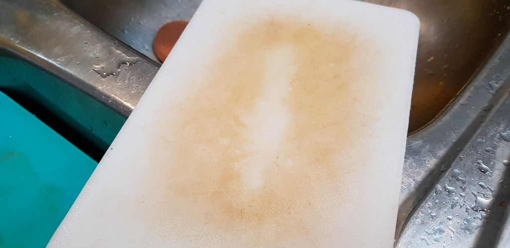 A small cutting board cleaned by a sponge alone. It's slightly less clean than the lemon side.
